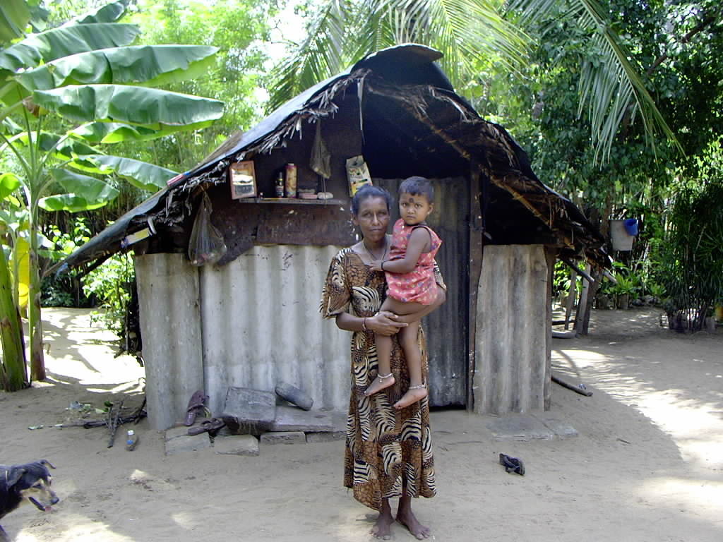 Familie vor einer einfachen Hütte