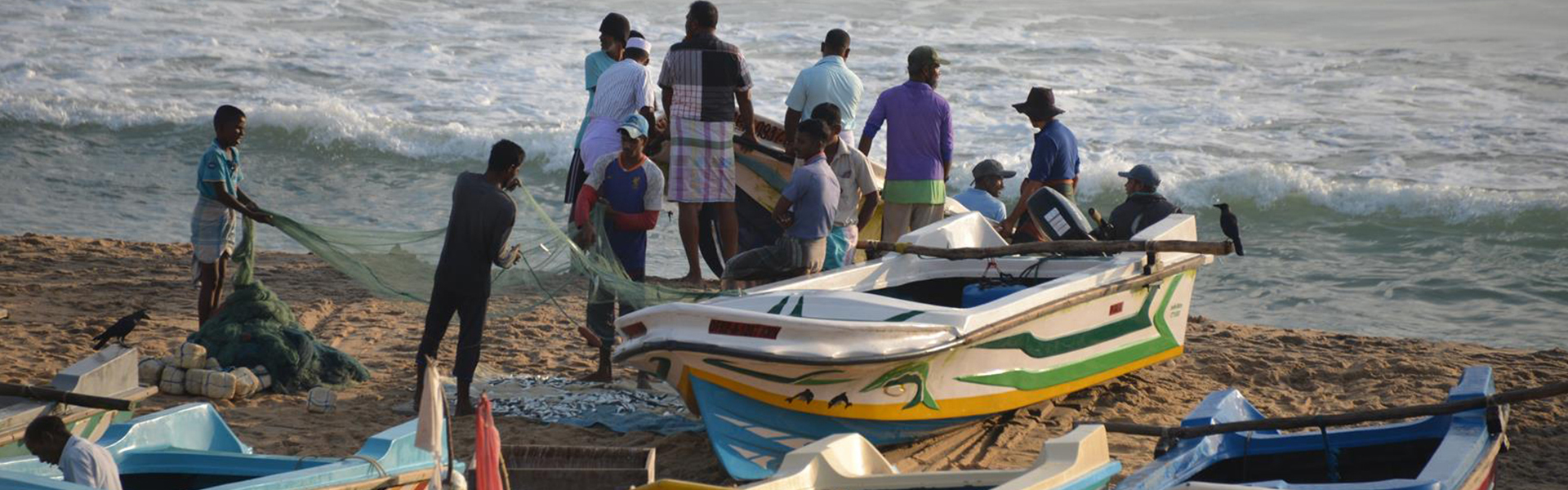 Fischer bringen Boote und Netze am Strand von Sri Lanka ein